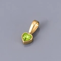 Macro detail of heart-shaped olive green zircon pendant with polished gold plating - August