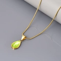 Detail van groene waterdruppel hanger met gouden slangenketting op grijze achtergrond - Goud-Groen