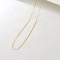 Close-up of adjustable golden stainless steel twist chain necklace with shimmering texture - S-Chain