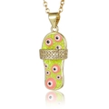 Macro detail of gold flip-flop pendant with green enamel and pink evil eye charms - Yellow