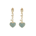 Details von goldenen Hängeohrringen mit Love-Schriftzug und blauen Herzanhängern - Himmelblau
