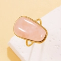 Gold stainless steel ring featuring a smooth natural pink quartz stone in a twisted band design - Rose Quartz