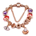 Rose gold sunflower charm bracelet with purple crystals and shell pearls on white background - Rose Gold Shell Evil Eye Style (Z*09)