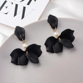 Detail of matte black petal earrings with white pearl accent on grey display tray - Black
