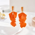 Bohemian orange layered petal tassel earrings with golden studs on white satin backdrop - Orange
