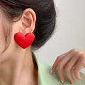 Close-up of oversized red heart-shaped earrings with a matte frosted finish on a model - Matte Heart Red