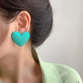 Close-up of mint green matte heart earring worn by a model in soft lighting - Light Green (Heart)