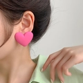Close-up of a large matte pink heart earring worn on ear with soft artistic lighting - Matte Heart Rose Red
