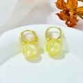 Close-up of golden hoop earrings with iridescent mermaid pearl drops on white silk - Pale Yellow/Light Green (A411)