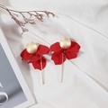 Detail of red petal drop earrings with gold rod on white wrinkled fabric - True Red
