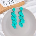 Detail of matte teal petal tassel earrings cascading on a ceramic tray for a chic look - Lake Blue (Style A)