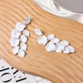 Detail of white matte petal earrings with gold chain on a textured wooden tray - White (Type A)