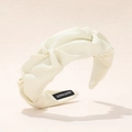 Détail d'un serre-tête torsadé crème montrant la texture sergé et l'étiquette artisanale - Blanc