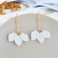 Close-up of white petal earrings with golden hooks on a minimalist gray ceramic tray - White Petal (A1165)