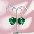 Detail of vintage gold-tone earrings with dark green petal pendants on a metal display stand - Dark Green Style (A1180)
