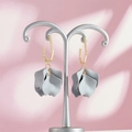 Detailed view of grey matte petal earrings with gold geometric hooks on a pink display - Gray Style (A1182)