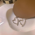 Elegant silver hollow heart earrings with metal cross design on a white ceramic plate - Silver Crossover Heart Style (A478)