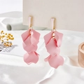 Close-up of pink matte petal drop earrings with layered floral design on a silk background - Pink