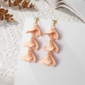 Detailed macro of layered apricot petal earrings with golden heart studs on white lace - Beige (A1220)