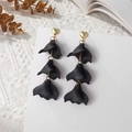 Close-up of long black matte petal earrings with golden heart studs on white card - Black (A1224)