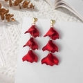 Detail of red tiered petal earrings with gold heart studs on a vintage book background - Pearly Red (A1213)