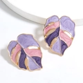 Golden monstera leaf earrings with purple enamel inlay on white pedestal background - Purple Gradient Monstera Leaf (A1345)