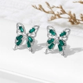 Macro view of silver butterfly stud earrings with emerald green zircon stone settings - Green (A1562)