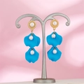 Detailed close-up of blue petal earrings with white pearls on a pink silk background - Bright Blue (A1393)
