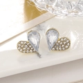 Detail of heart stud earrings with emerald-cut zircon in gold finish on marble tray - Clear Style (A1474)