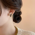 Elegant gold butterfly earrings with black enamel and zircons worn by a model - Black Butterfly (A129)