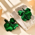 Macro detail of dark green matte floral petal earrings on light stone with soft shadows - Holographic Green