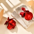 Macro shot of matte red flower petal earrings on a stone textured surface - Pearlescent Red