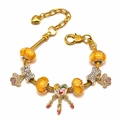 Detailed shot of a gold-tone DIY charm bracelet with orange beads and heart dreamcatcher - Style 005