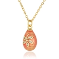 Detailed macro of a gold egg pendant with orange enamel and zircon flower inlay - Lotus root pink