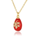 Detailed macro view of red enamel egg pendant with gold flowers and micro-set zircons - Red