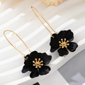 Details von mattschwarzen Blumenohrringen mit goldenen Staubblättern und Ohrbügeln - Schwarz