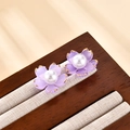 Macro view of purple flower stud earrings with pearl centers on beige velvet - Purple Flower Style (A439)