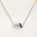 Elegant gold necklace with emerald cut clear stone and blue marquise gemstone - December