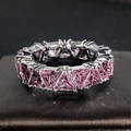 Vista macro di un anello eternity di lusso con pietre rosa taglio triangolo e argento - US 5 / Rosa