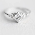 Elegant princess cut cubic zirconia ring with side stones in a bright silver finish - US 7 / White Gold