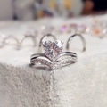 Detailed macro view of heart-cut crystal ring with micro-paved V-shaped silver band - White Gold / US 6