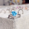 Macro shot of silver heart ring with aquamarine gemstone and pavé V-shaped band - Blue