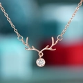 Macro view of rose gold reindeer antler necklace with a sparkling round zircon pendant - Rose Gold