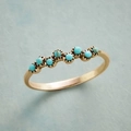 Macro detail of gold ring with seven turquoise stones in a minimalist wavy setting - Size 8 / Gold