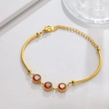 Detail of gold bamboo link bracelet featuring three red gemstones and adjustable lobster clasp - Round Red Gem Gold
