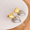 Detailed view of bicolor heart-shaped stud earrings in gold and silver metal finishes - Two-tone Gold (Small)