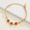 Detail view of golden bamboo chain bracelet featuring red star gems and lobster clasp - Bamboo Link Star Red Gem Gold