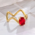 Primer plano de un anillo ondulado dorado con una gran gema roja ovalada y engaste de garras - US 6 / Ovalado Ondulado Circonita Rojo Dorado