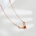 Close-up of rose gold antler pendant with a dark projection stone and zircon inlay - Rose Gold
