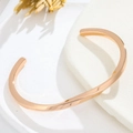 Gros plan détaillé d'un bracelet jonc spirale en or rose sur un socle en pierre - Or Rose Homme
